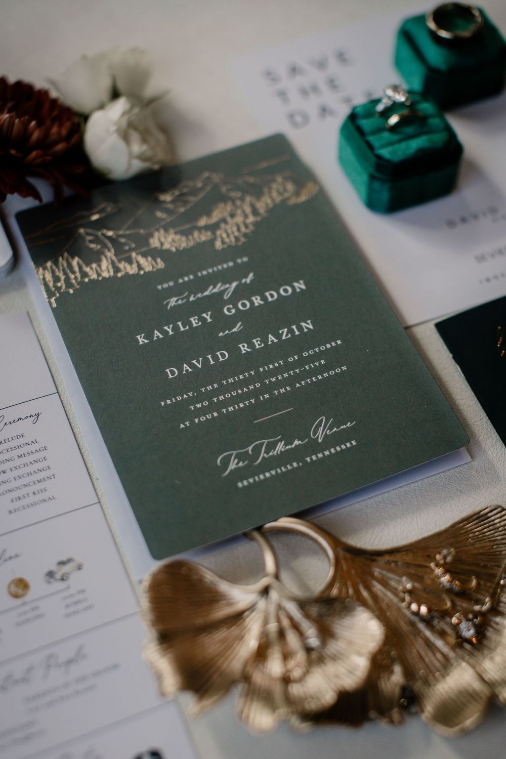 Elegant dark green wedding invitation with gold text and decorative elements on white paper.