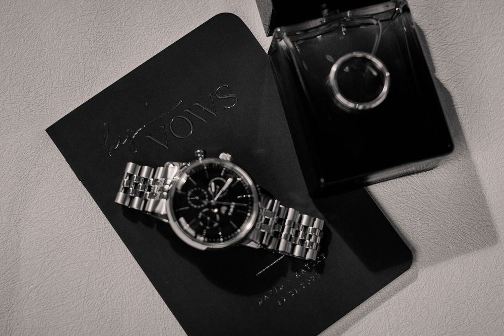 A collection of luxury watches displayed on black surfaces in a monochromatic style photograph.