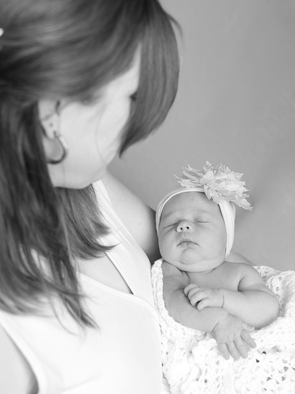 High-key black and white series of newborn with delicate lace accessories.