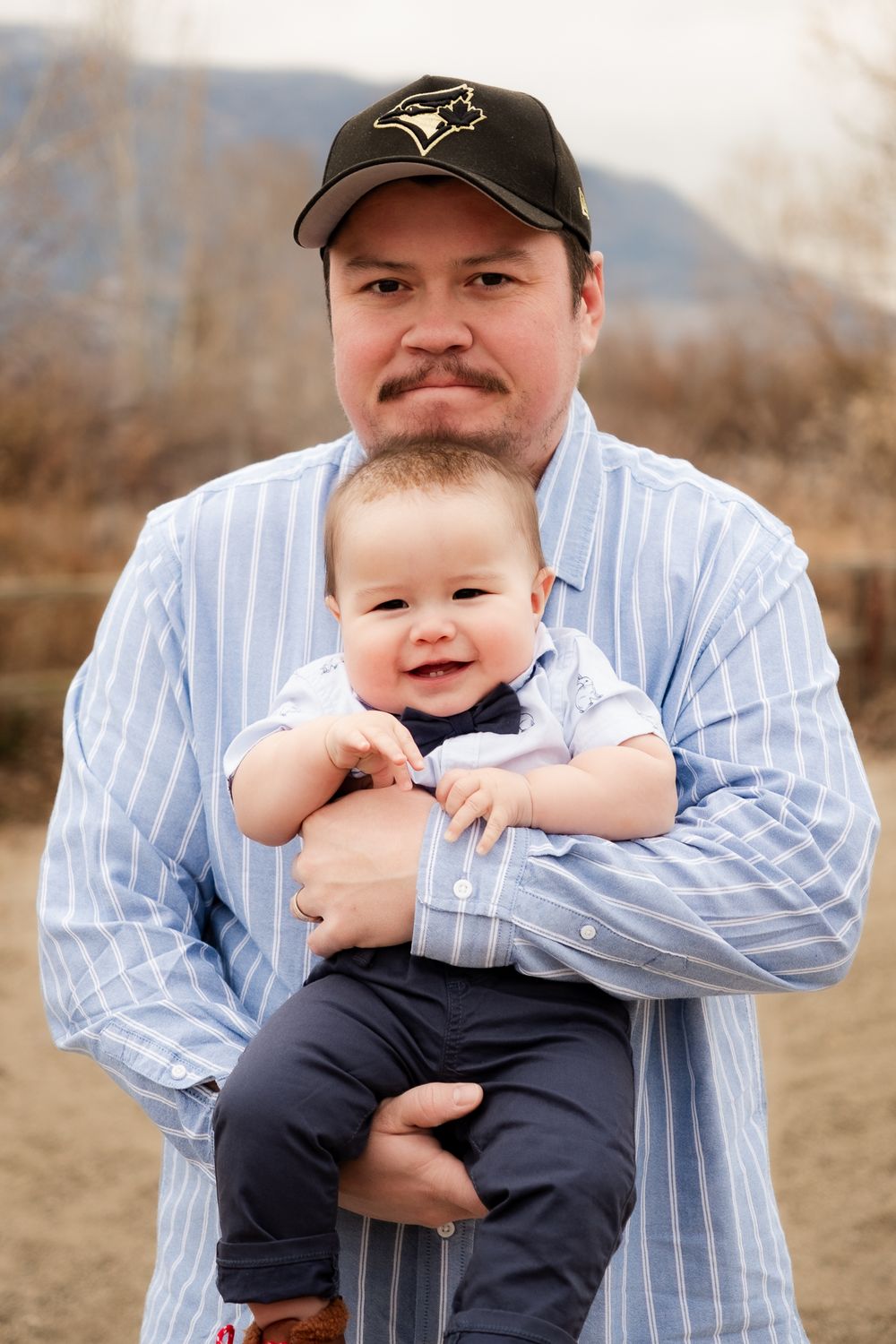 Adorable father and son portrait in light blue matching shirts.