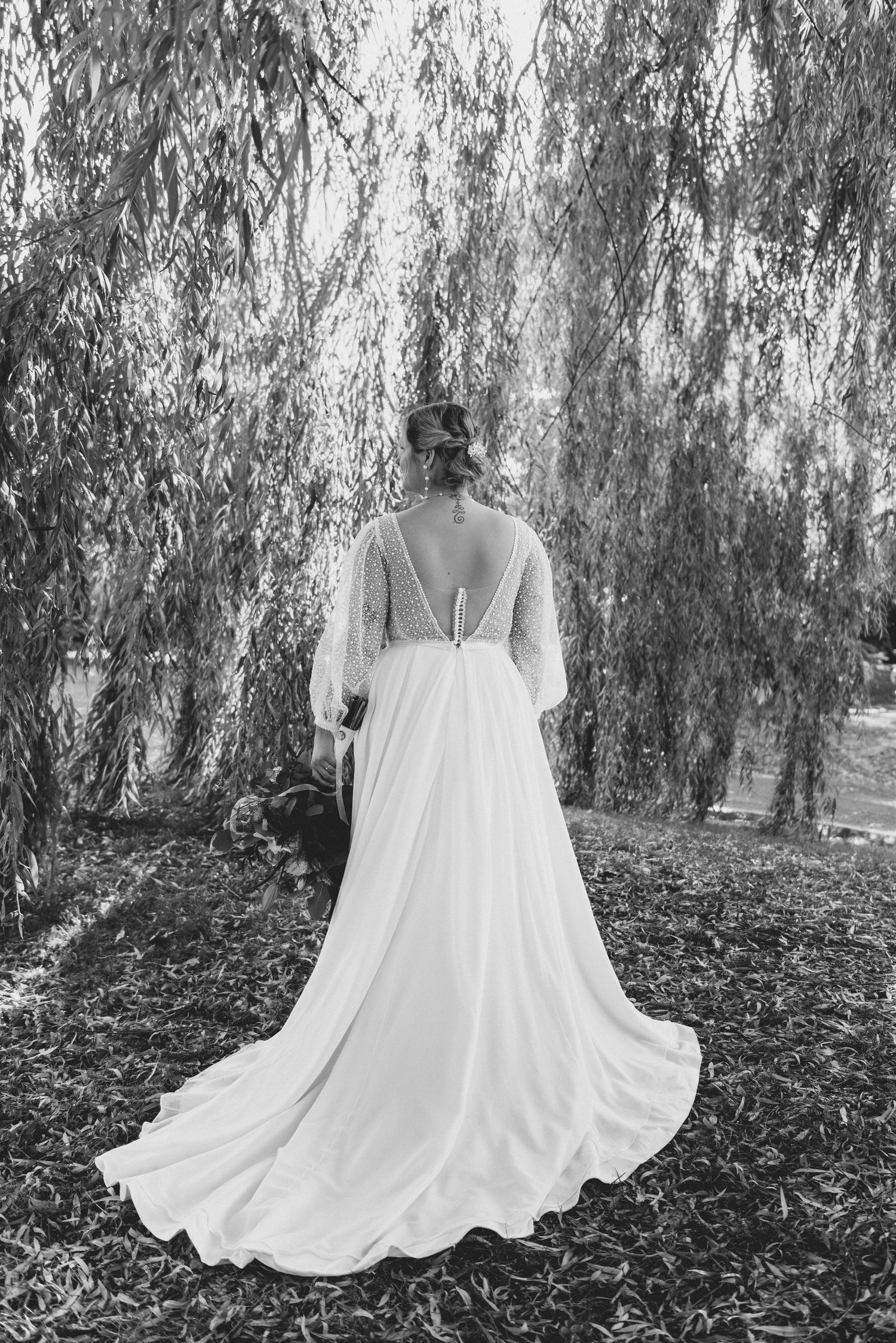 A white flowing dress photographed in sequence against a backdrop of willow trees and fallen leaves.