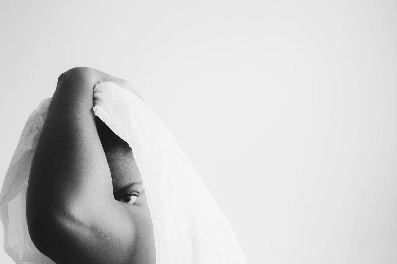 Close-up black and white detail of a wedding dress neckline showing delicate white fabric and plunging V-shape design.