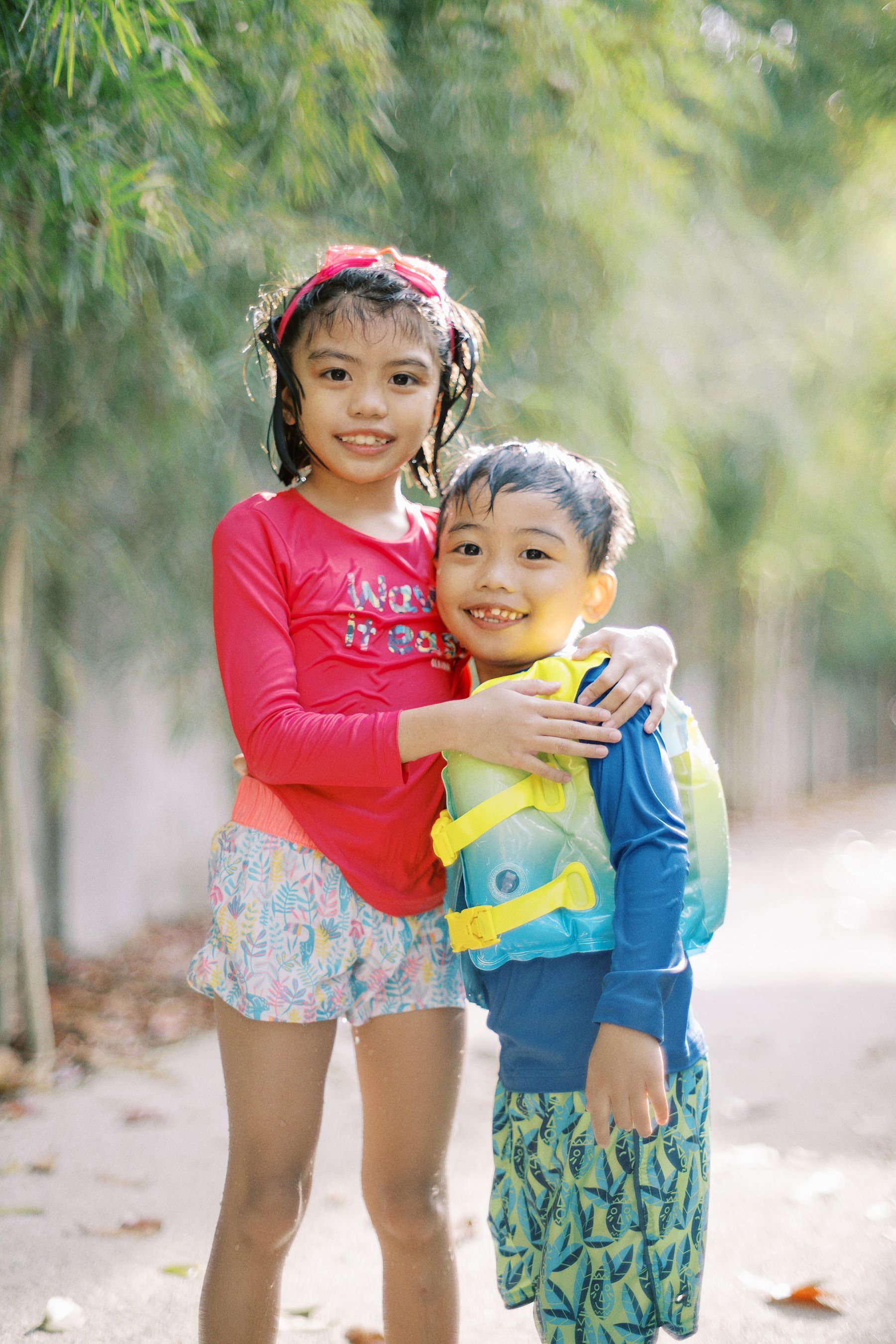 Two young children playing together outdoors on a sunny day.