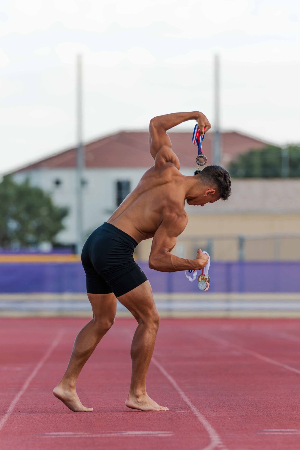 Sequence of an athlete in starting position preparing to sprint on a red running track.