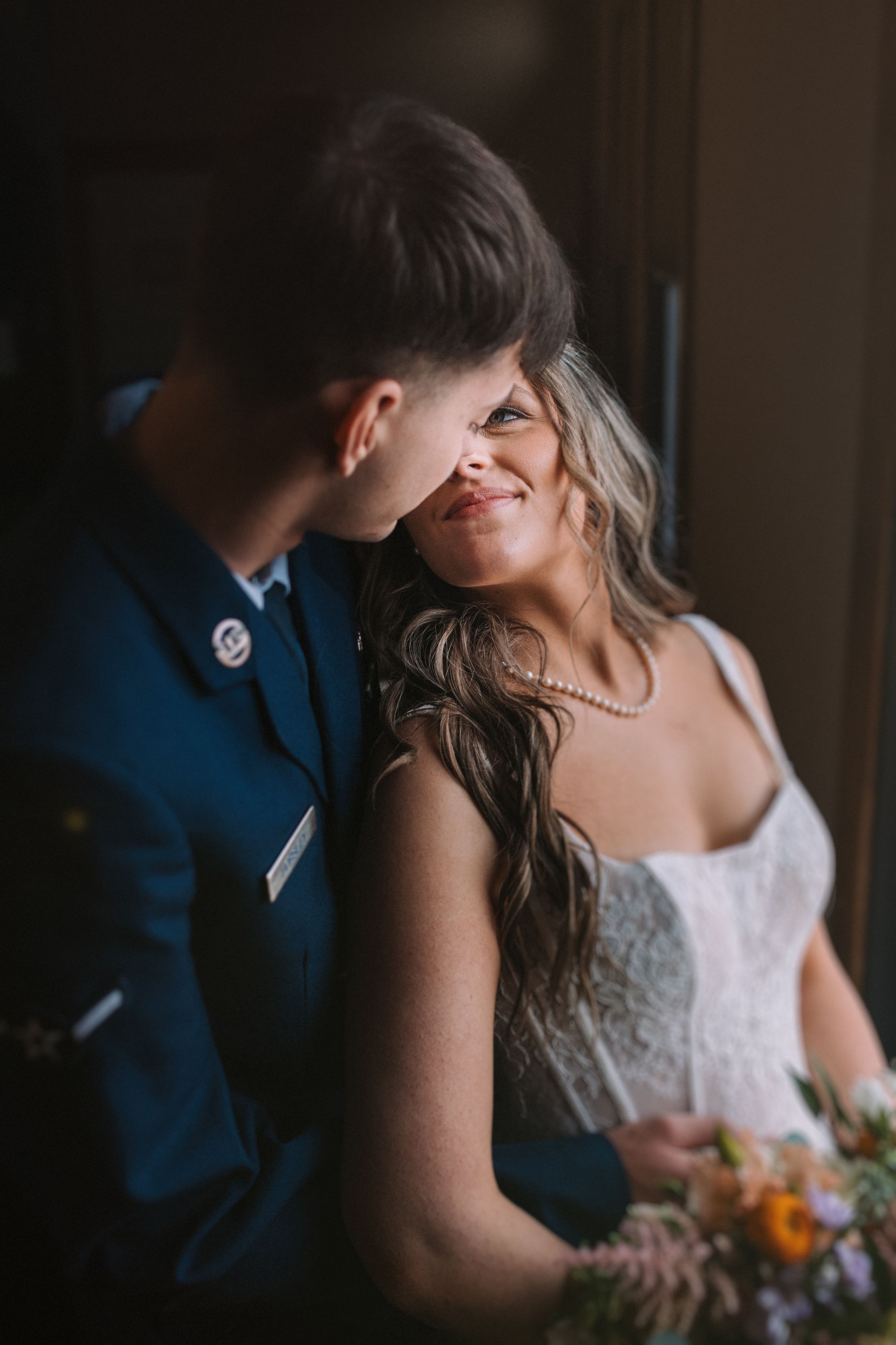 Intimate wedding moment between couple with bride holding colorful bouquet.