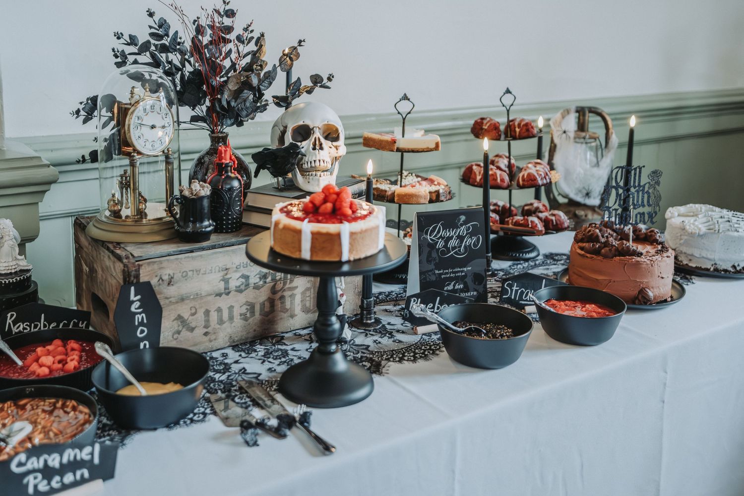 Rustic dessert table with cakes and treats decorated with greenery and holiday decor at a winter wedding reception.
