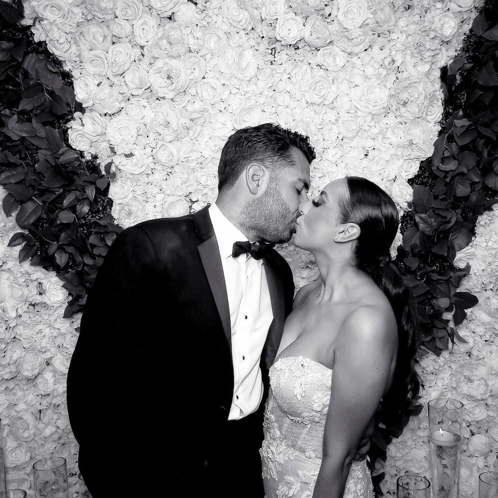 A romantic black and white photo series showing tender moments against a floral backdrop.