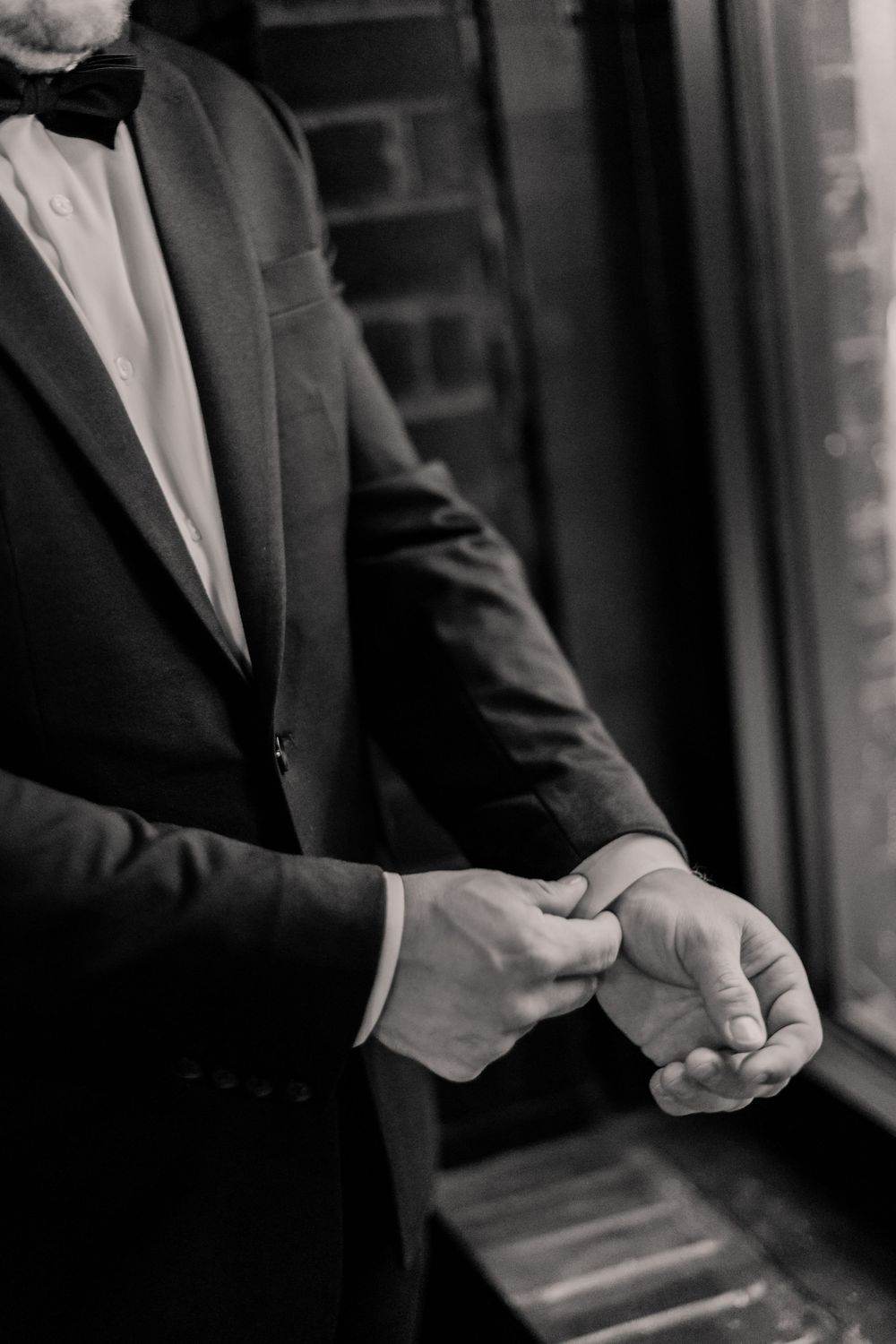 Black and white detail shots of formal suit adjustments.