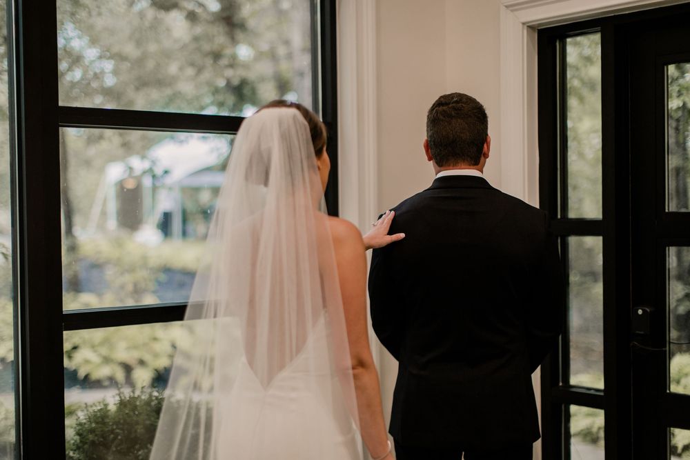 Wedding ceremony venue interior with large windows and natural light.