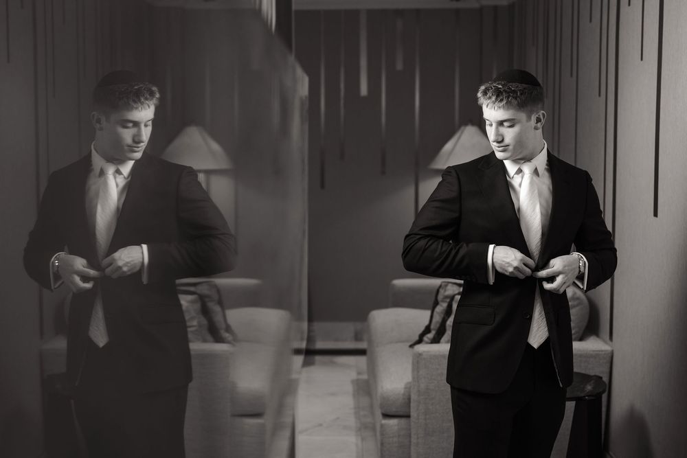 Black and white film strip showing a sequence of someone in a suit checking their watch in dramatic lighting.
