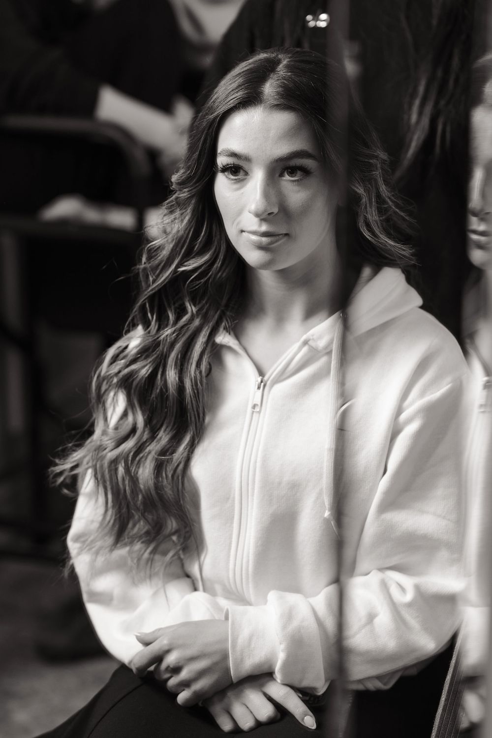 A series of black and white portraits showing someone in a white button-up shirt with flowing dark hair.