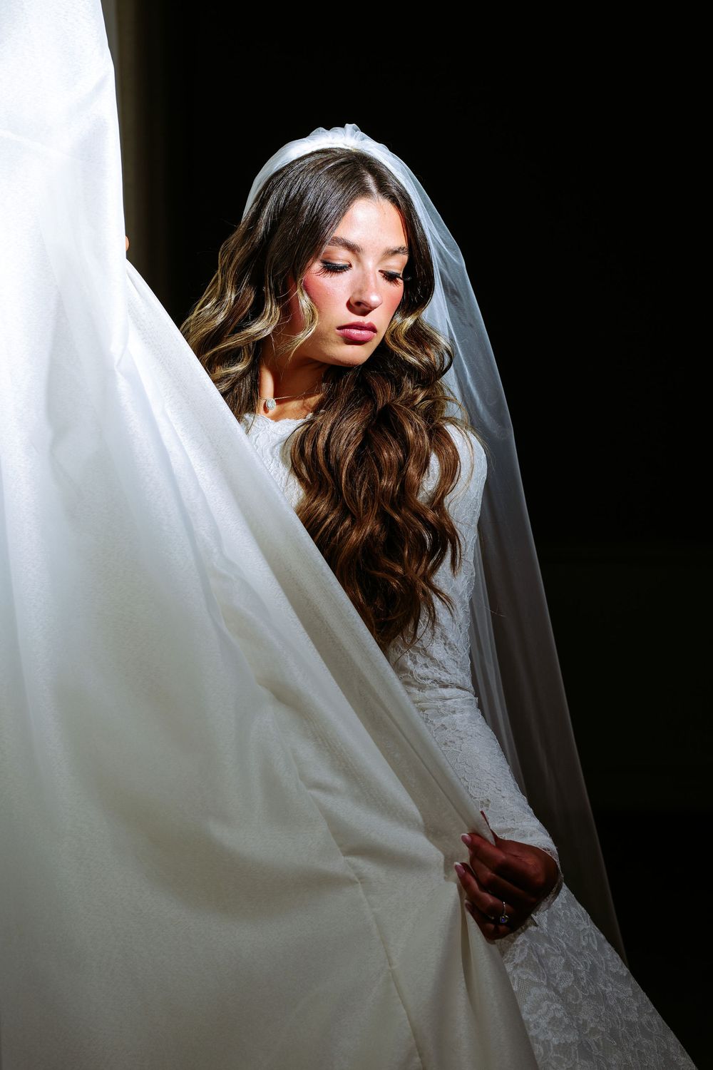 Artistic black and white bridal portraits highlighting a flowing veil and lace wedding dress details.