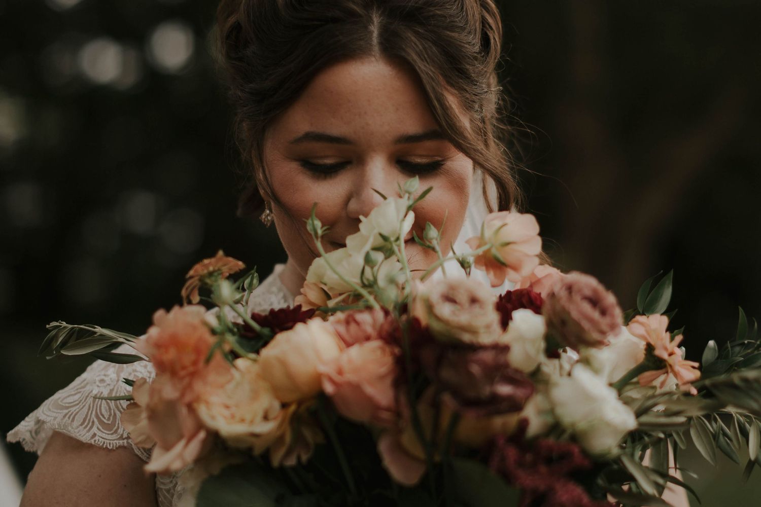 Delicate peach and blush wedding bouquet with roses and mixed flowers.