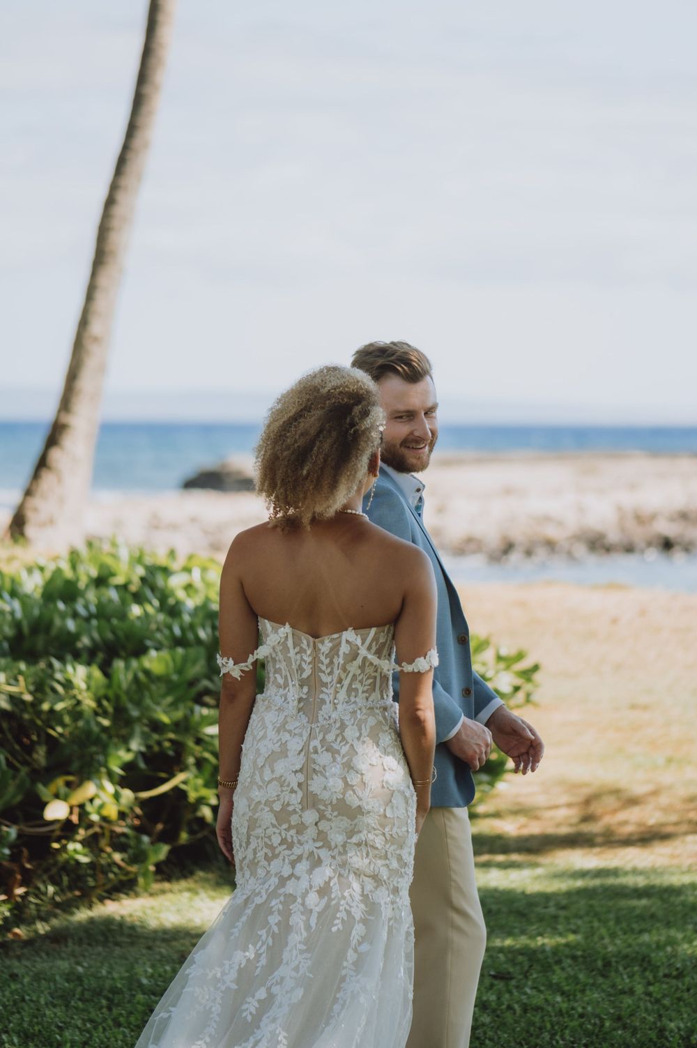 Beachside wedding portraits with palm trees and ocean in the background.