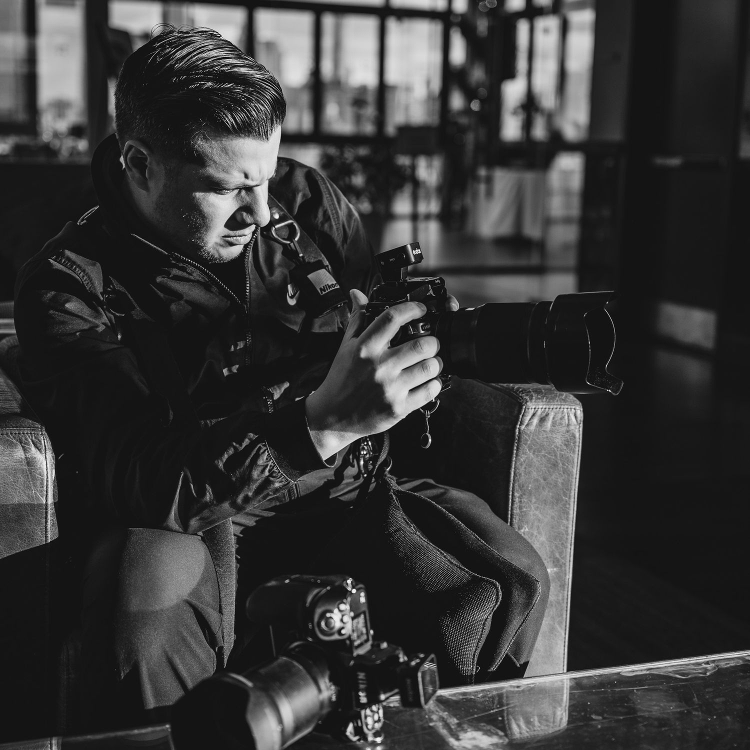 Dramatic black and white photo of a photographer working in low light conditions.