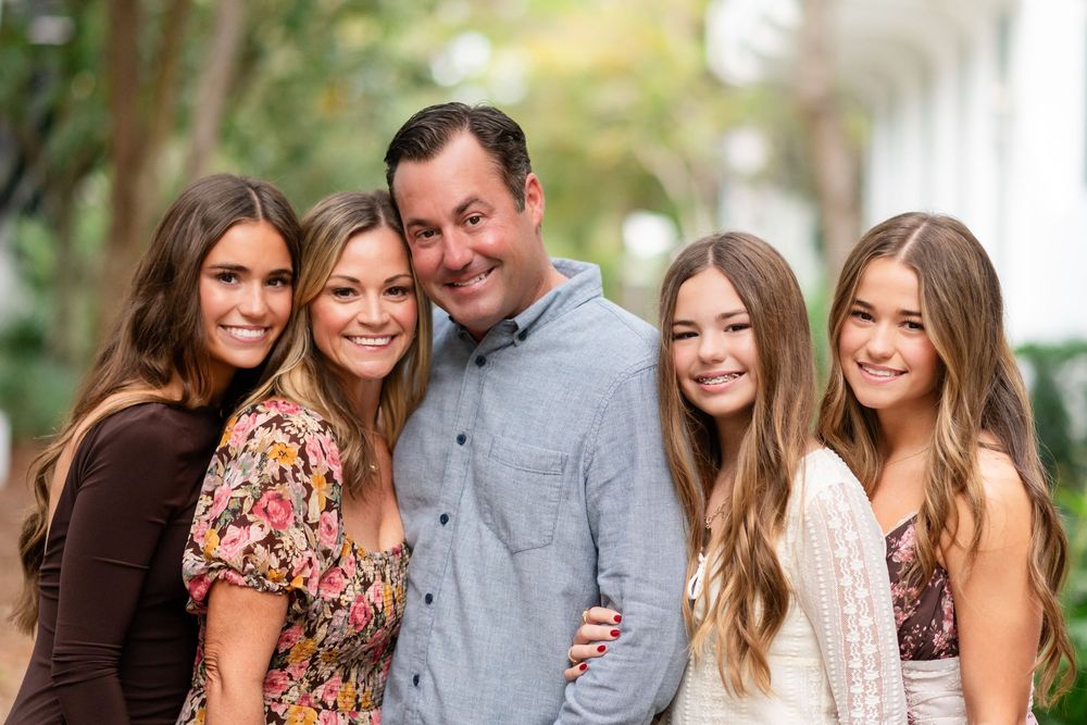 A collage of outdoor family portrait photos showing people in coordinated outfits posing together in a natural setting.
