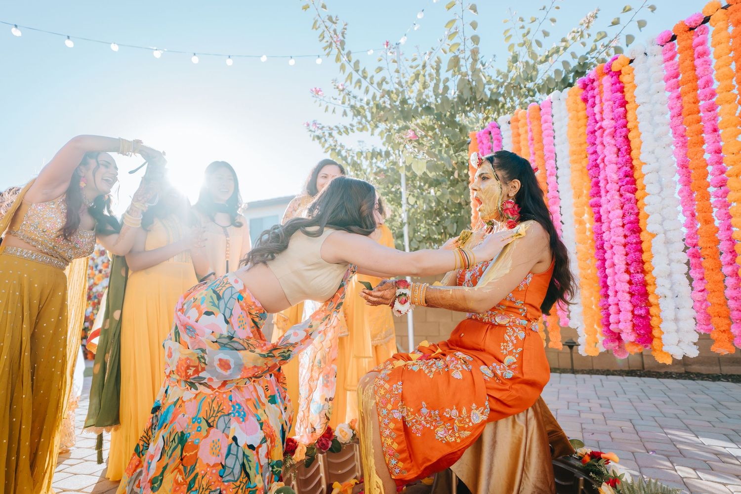 Vibrant outdoor celebration with orange and pink decorations during golden hour.