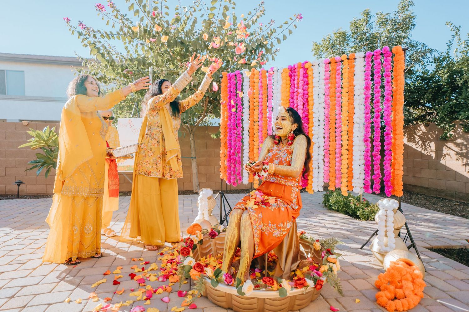 Traditional outdoor celebration with bright orange and pink decor elements and floral arrangements.