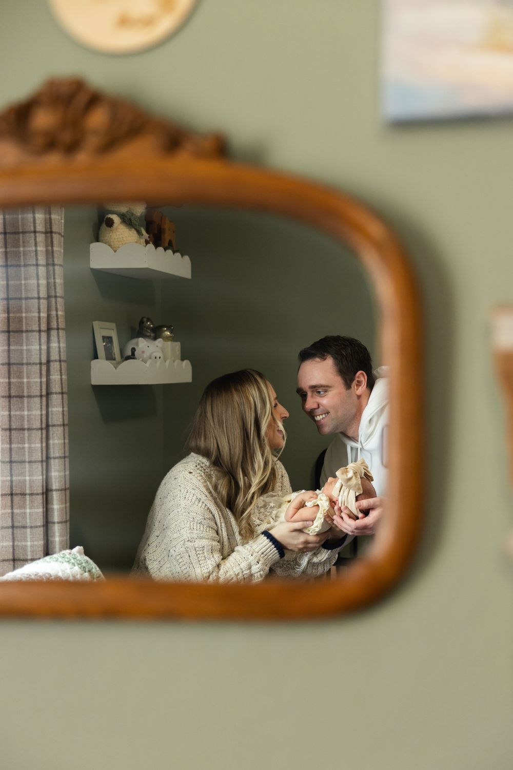 Reflections in a vintage mirror show intimate family moments in a soft, dreamy style.