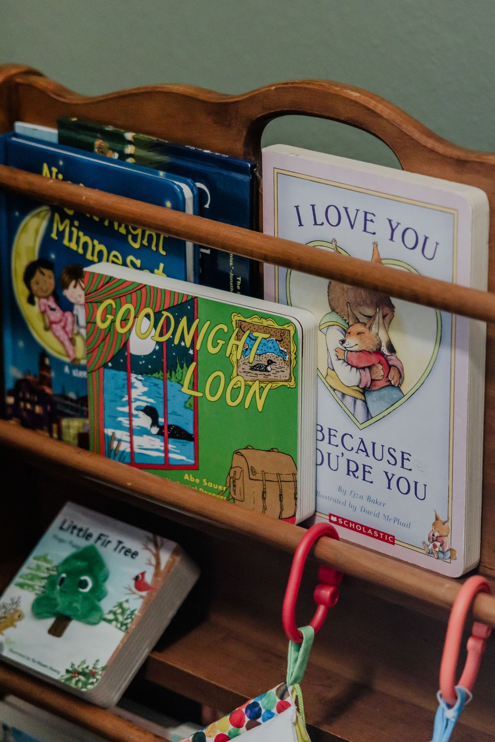Children's books including 'Goodnight Moon' displayed on wooden shelves with colorful bookends.