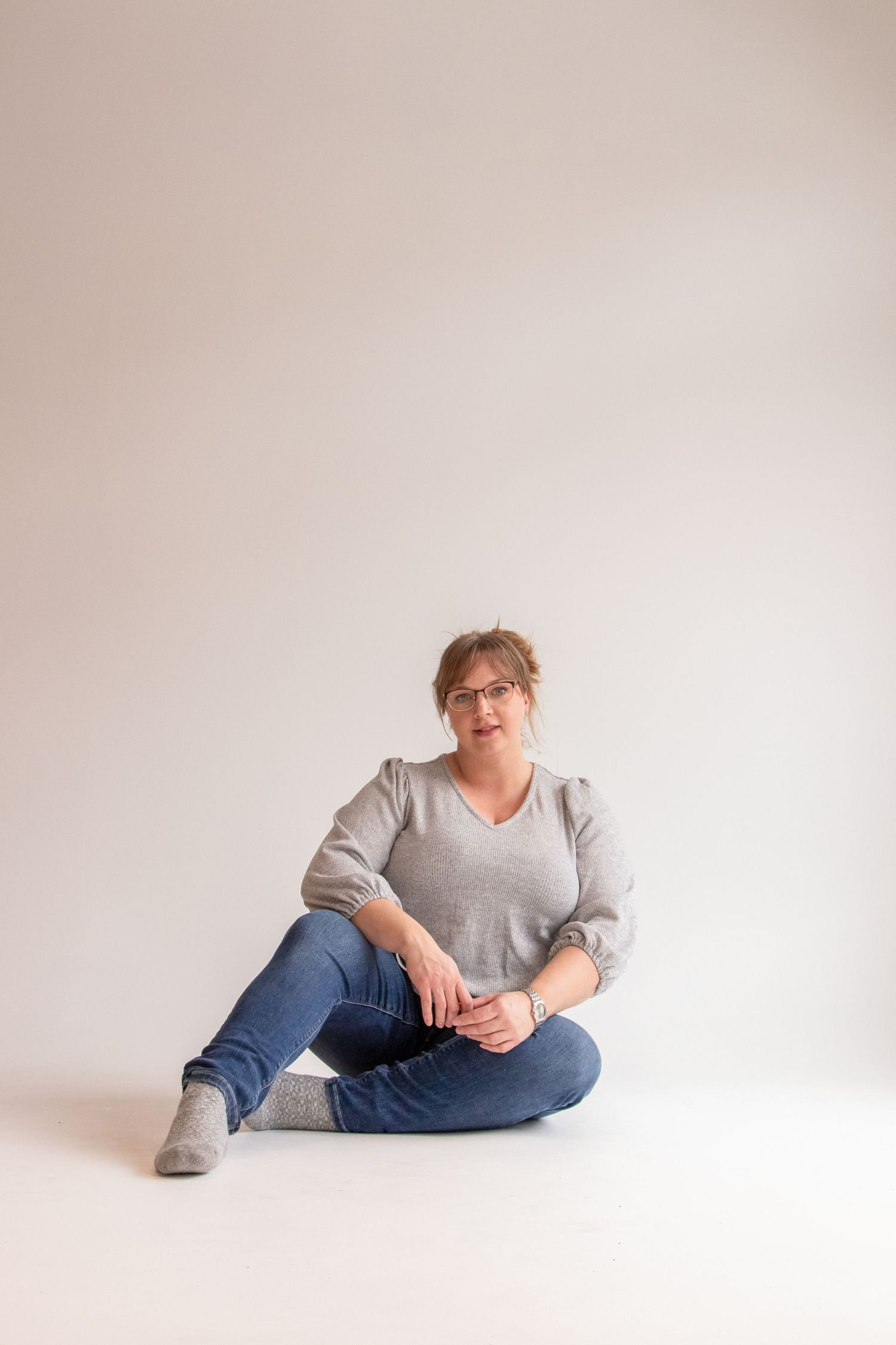 Studio portrait with minimalist background and casual styling.