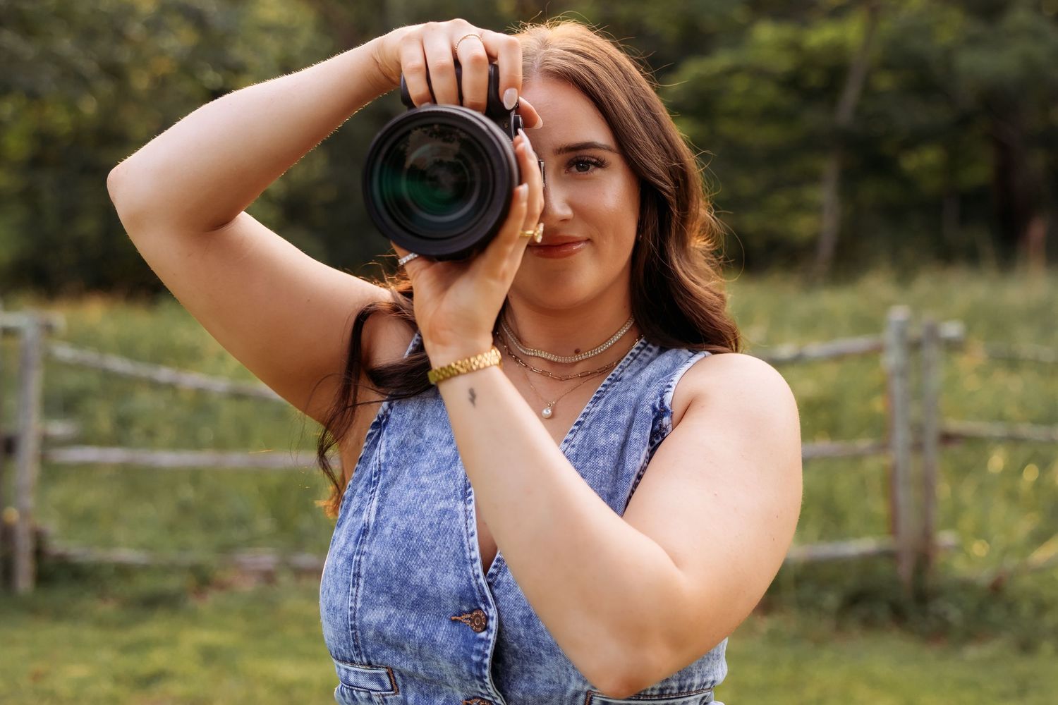 A photographer takes pictures in a countryside setting during golden hour.