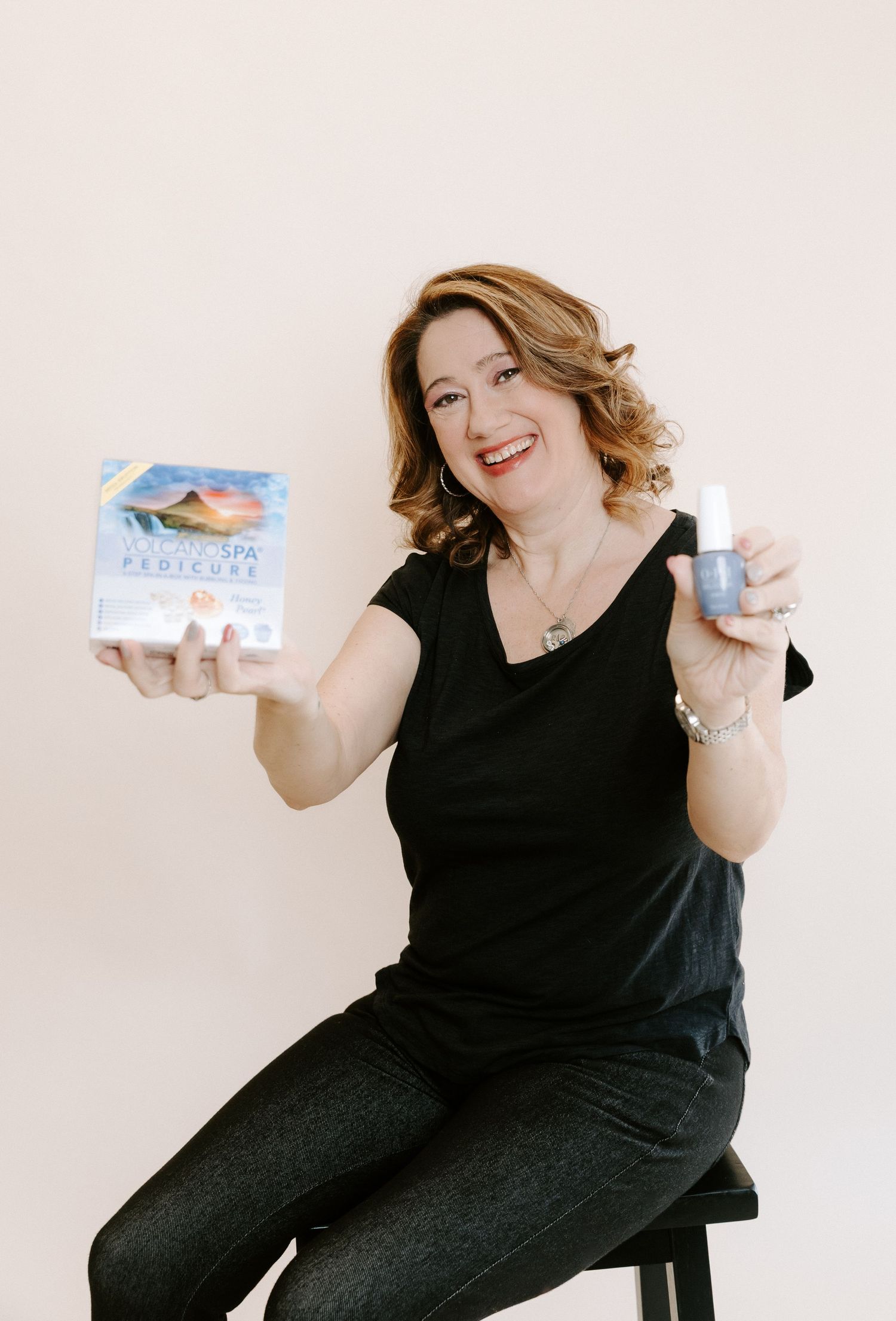 Person in black outfit displays small business cards or gift cards while sitting in different casual poses against white background.