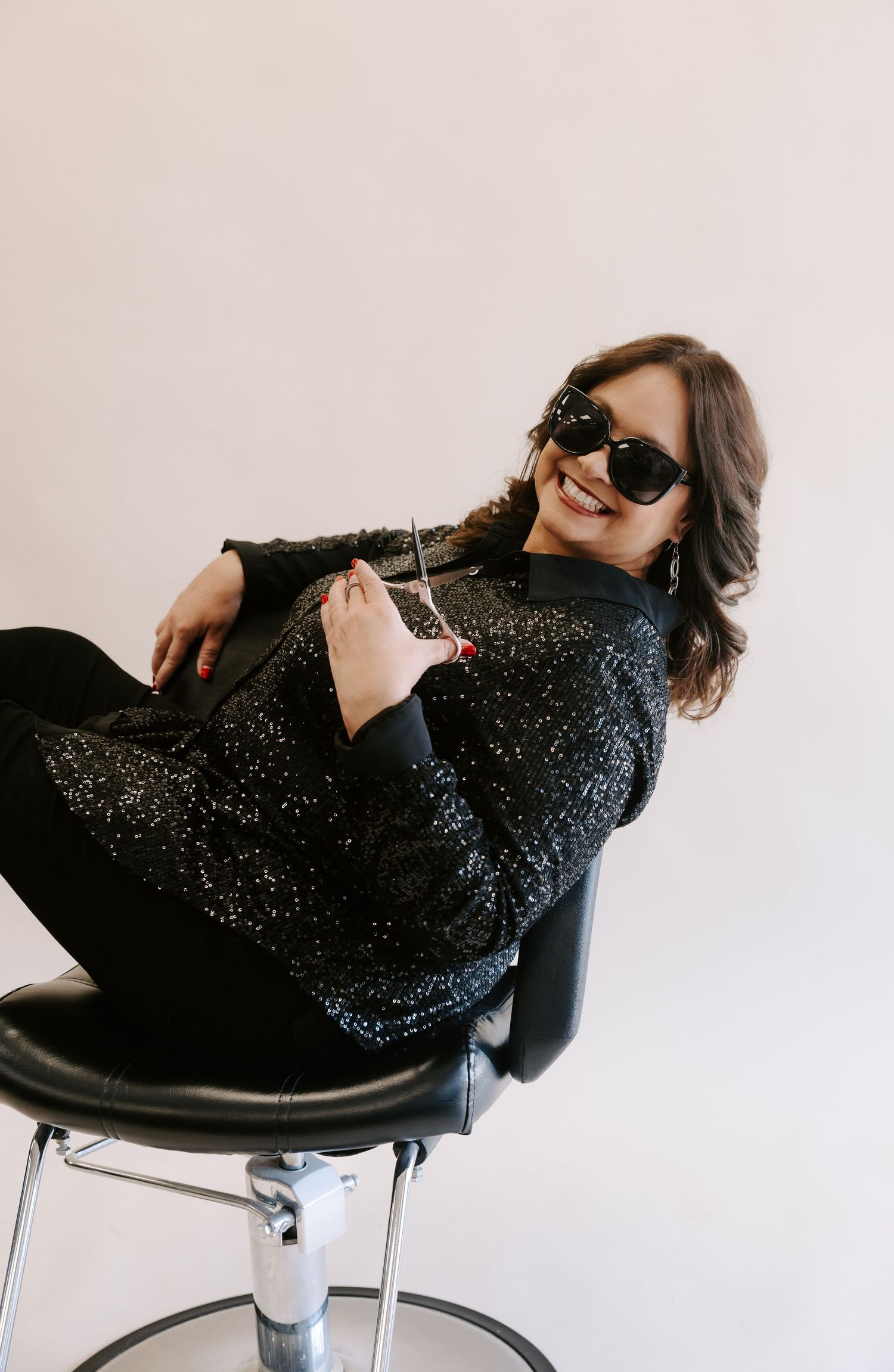 A sequence of photos showing a person in a sparkly black sweater reclining dramatically in a modern chair.