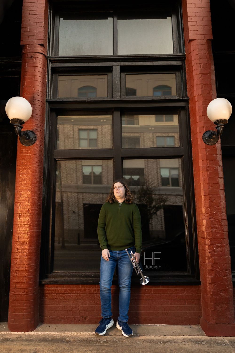 Architectural portrait session against red brick building with classic lamp posts.
