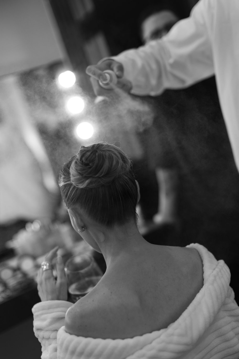 Black and white close-up portrait of a bride with soft lighting and bokeh effects in the background.