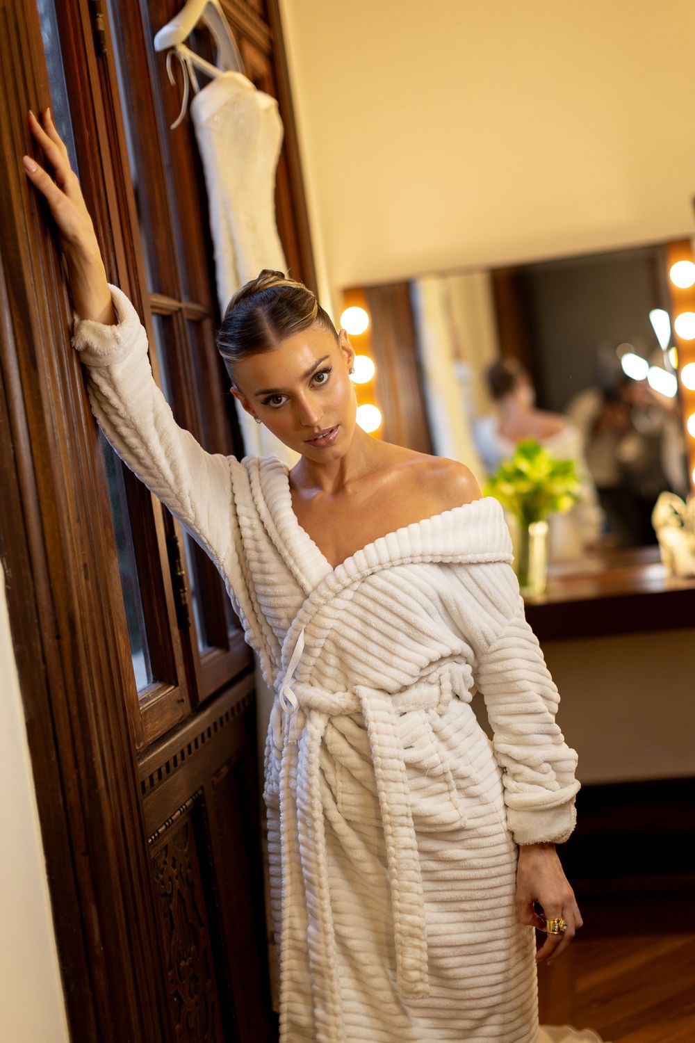 Elegant white turtleneck sweater shown in a warm interior setting with wooden details.