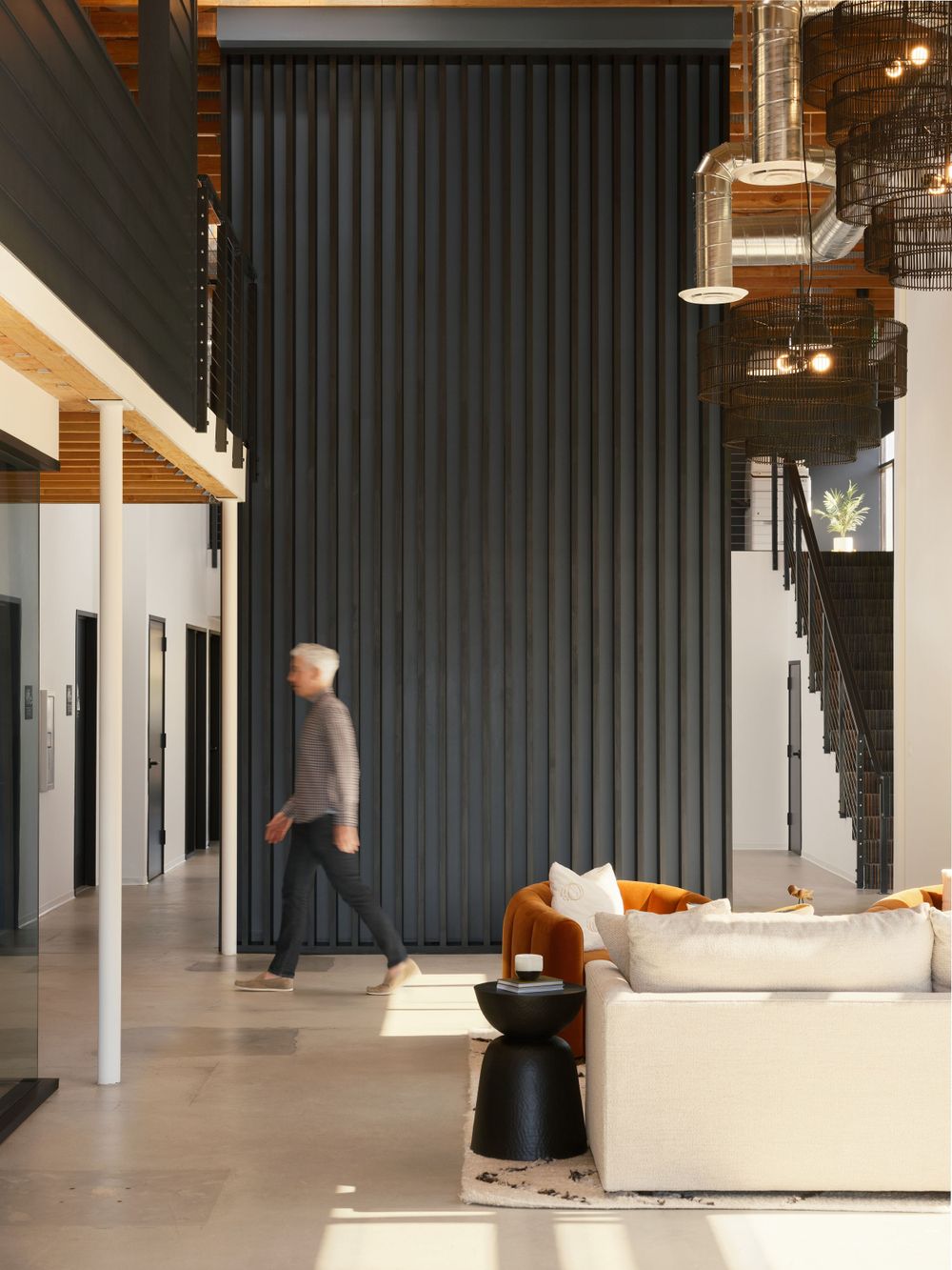 Lobby view with high ceilings, black accent wall, and lounge seating — commercial space photography by Khoi Ly.