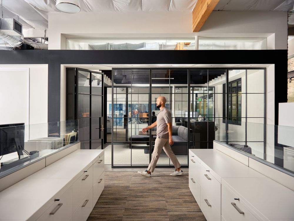 Contemporary office hallway with glass meeting rooms and natural lighting — commercial architecture captured by Khoi Ly.