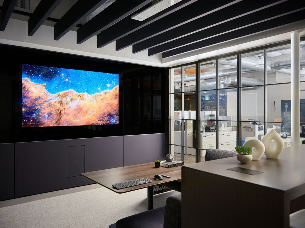 Conference room with large screen, dark ceiling beams, and modern furnishings — interior corporate design by Khoi Ly.