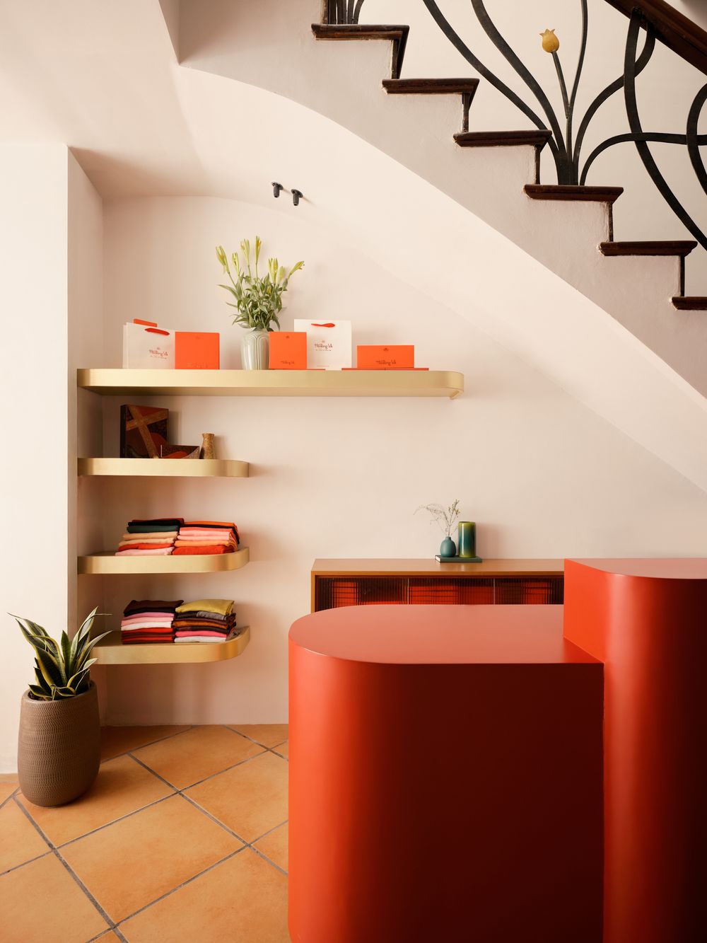 Creative shelving design beneath staircase in a retail setting — minimal boutique interior by Khoi Ly.