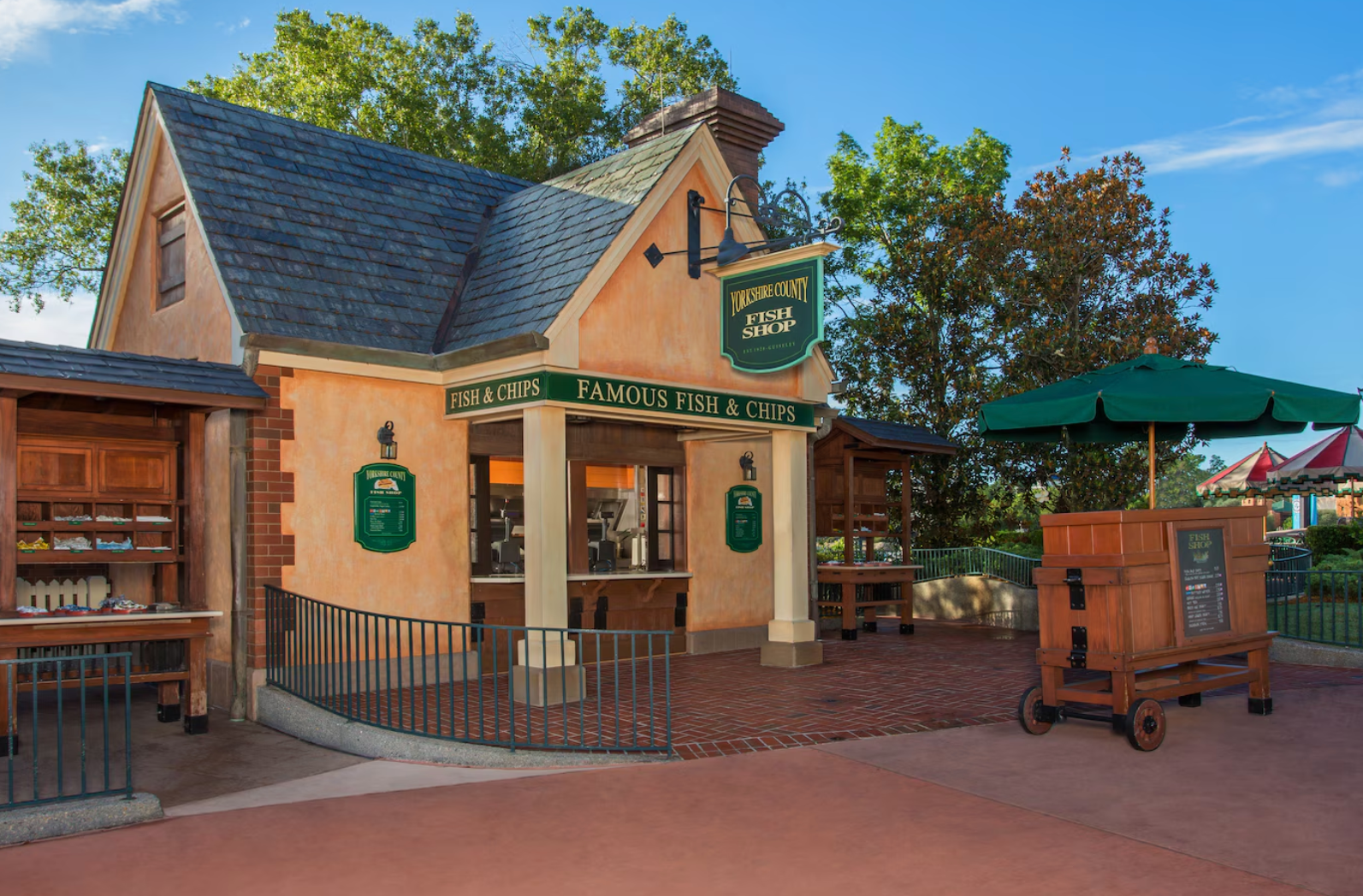 A quaint cottage-style building with green trim and outdoor seating area.