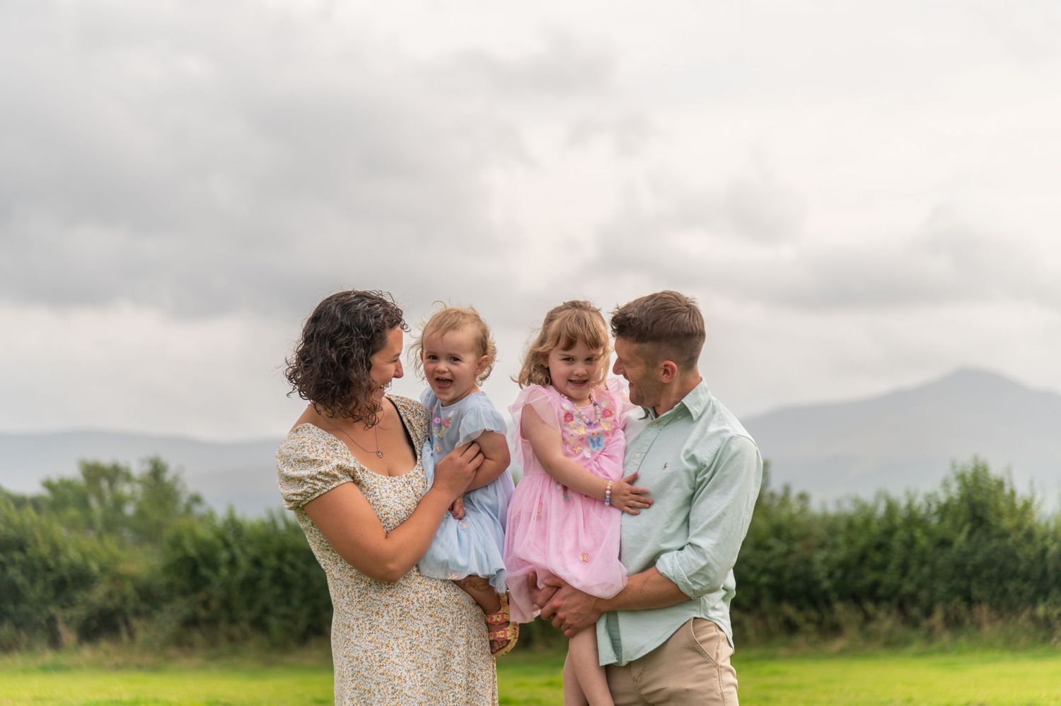 Family enjoying a tender moment together in a sunny field.