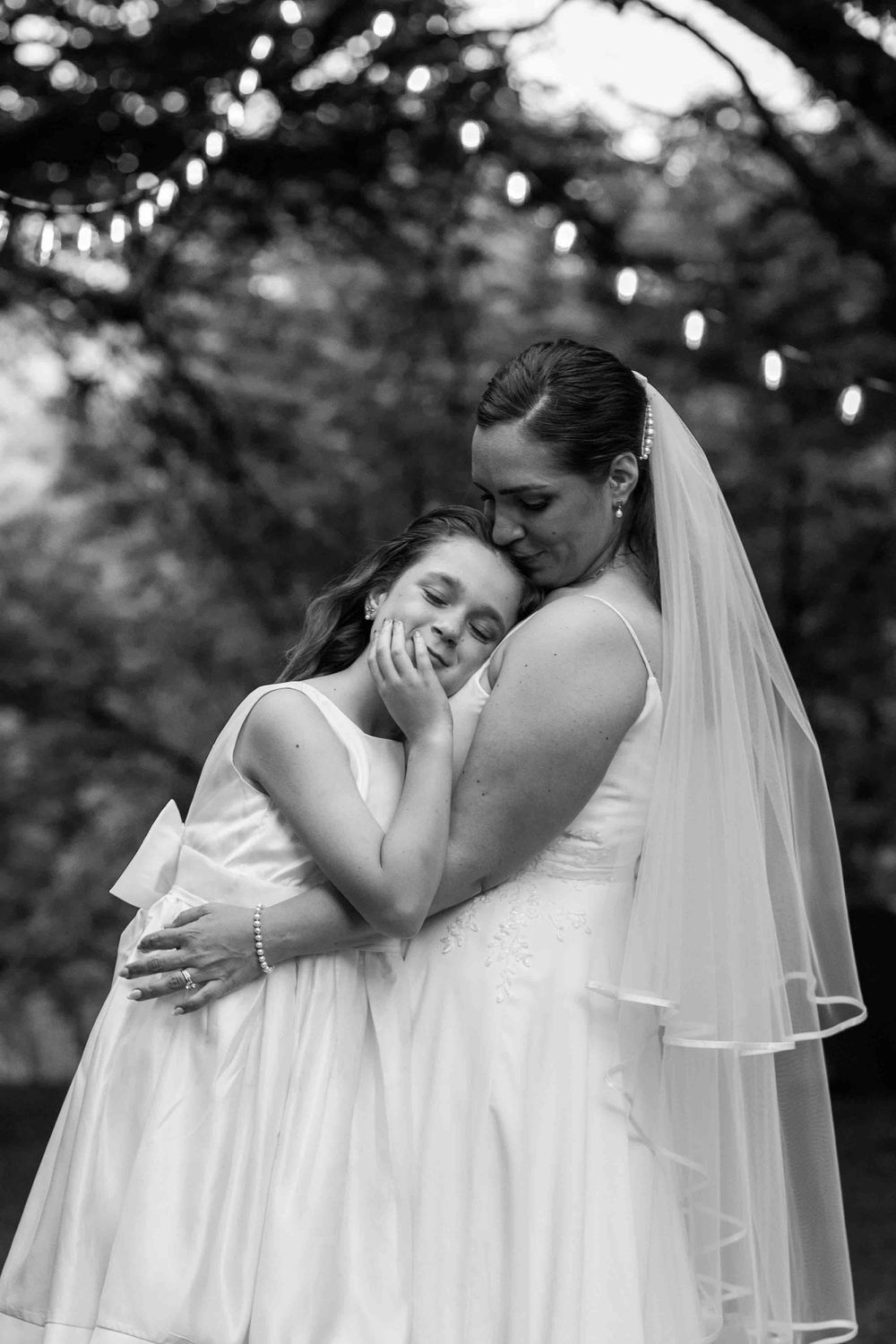 A tender black and white wedding photo sequence showing intimate moments between newlyweds with flowing veil details.