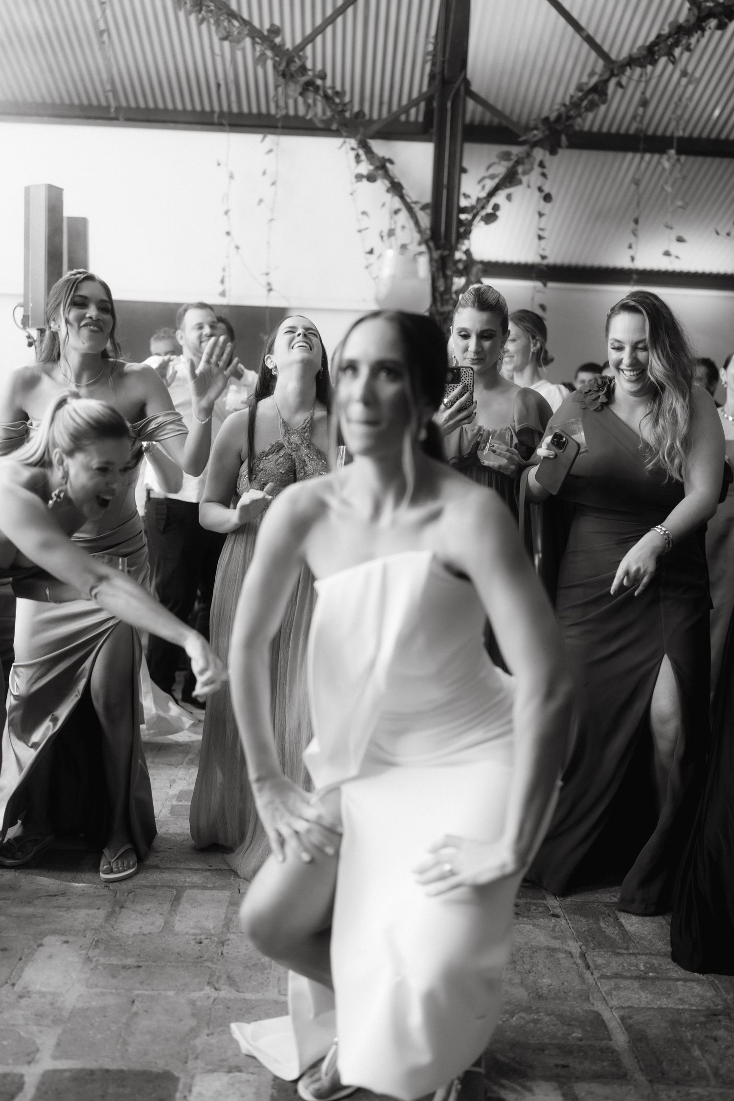 Group dancing together during a festive celebration in black and white photography.
