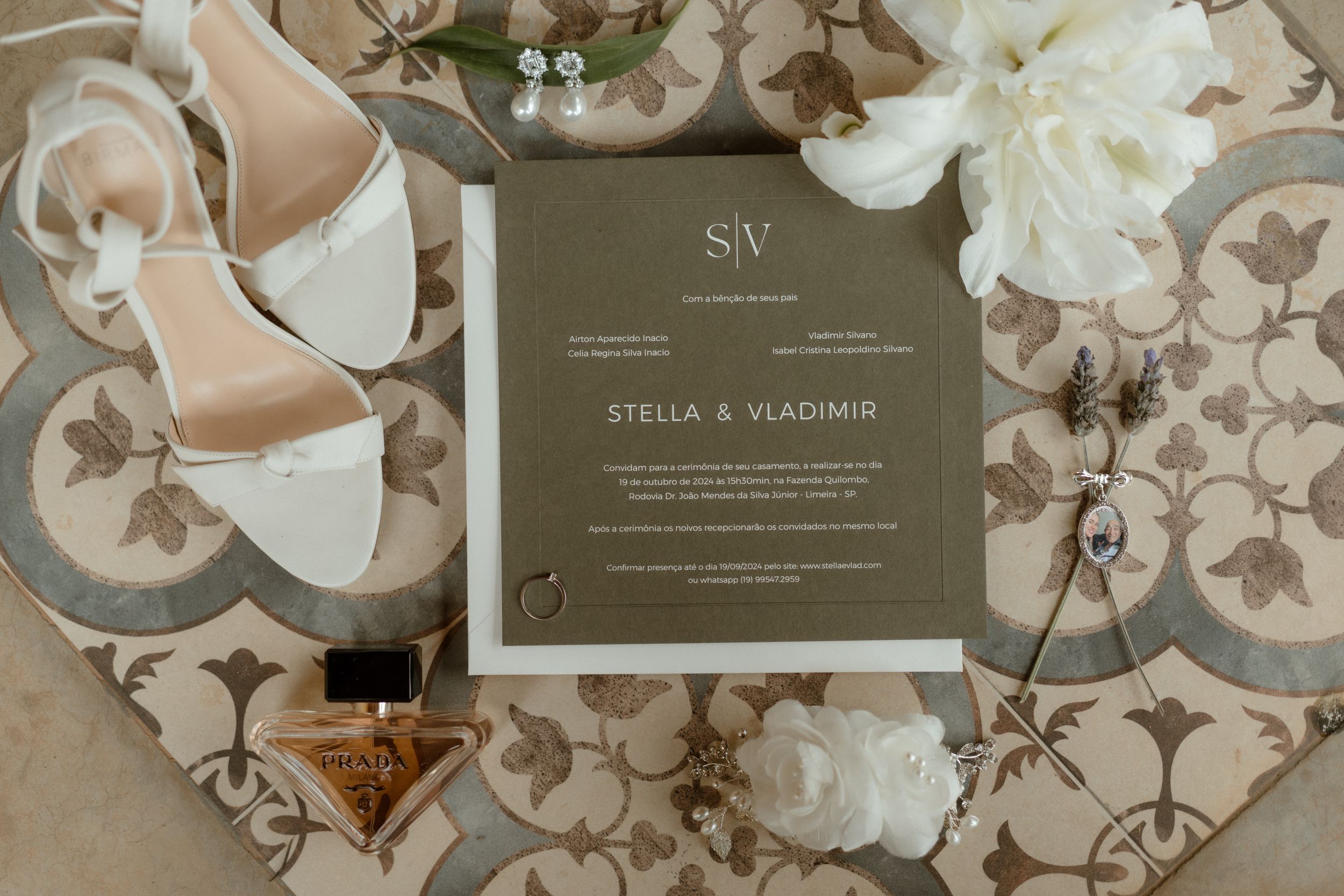 Wedding invitation cards and stationery laid out on floral patterned background.