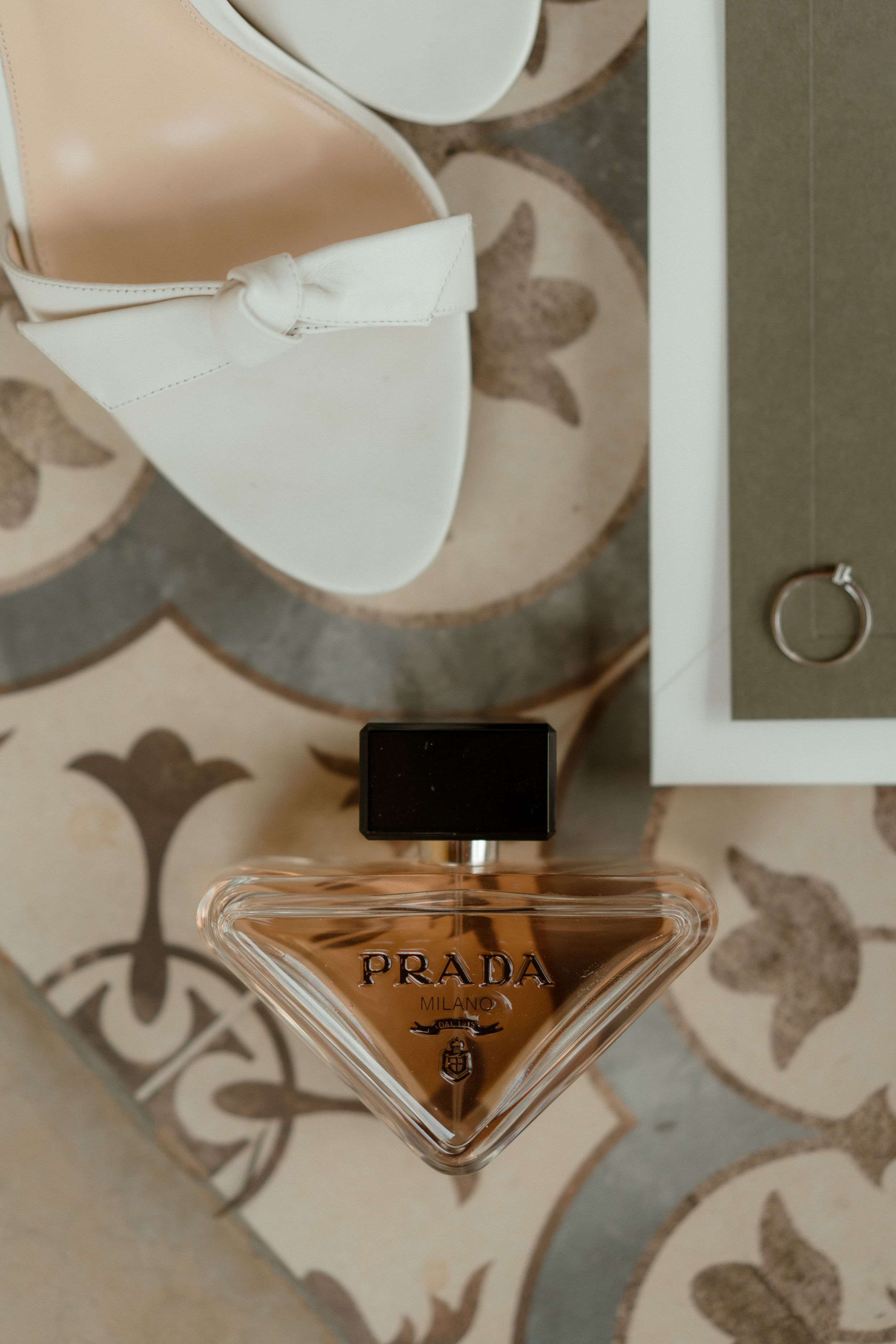 Luxury Prada perfume bottle displayed on patterned surface.