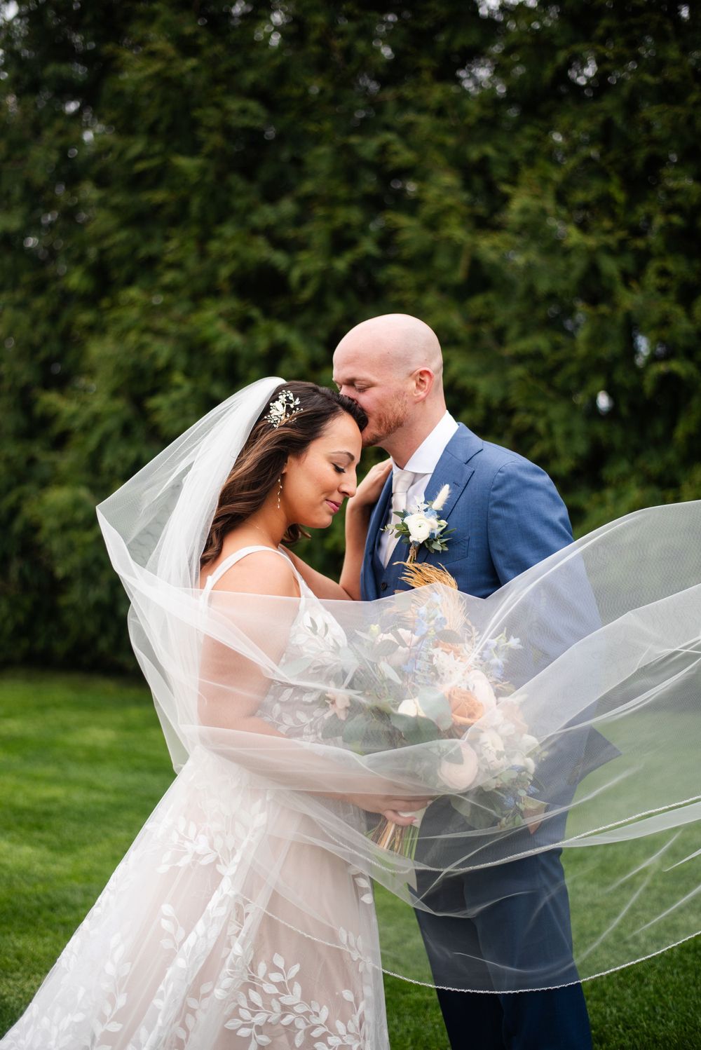 Couple embracing and veil blowing across