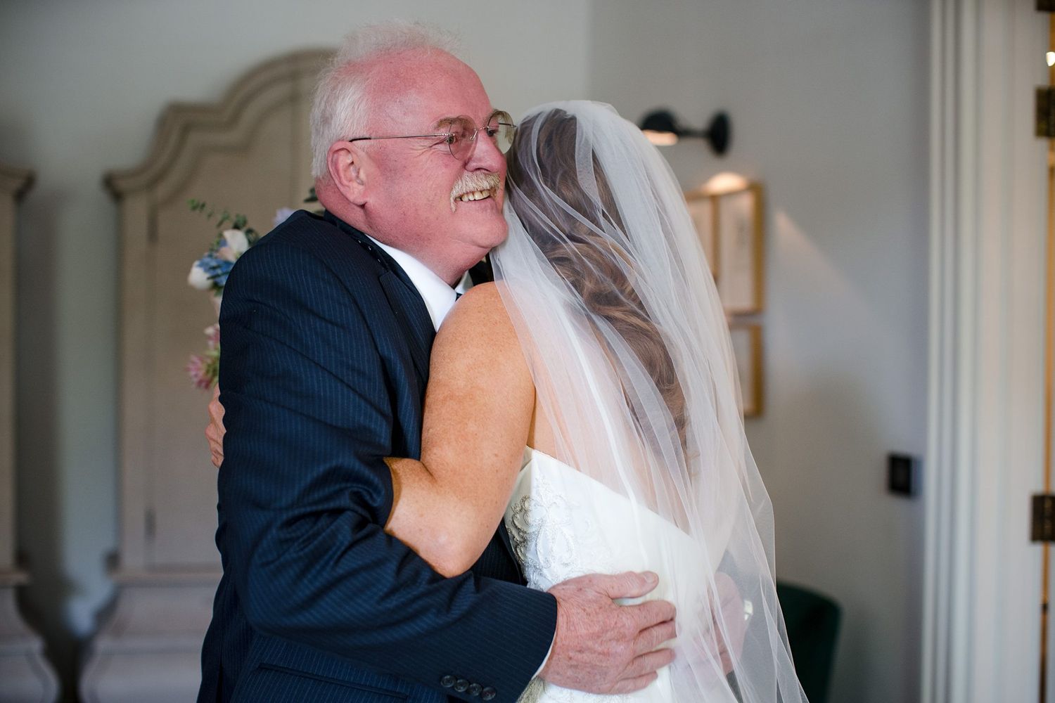 A tender embrace shared between a bride in white dress and father in a black suit during a wedding at The Westin Nova Scotian, Halifax, NS.