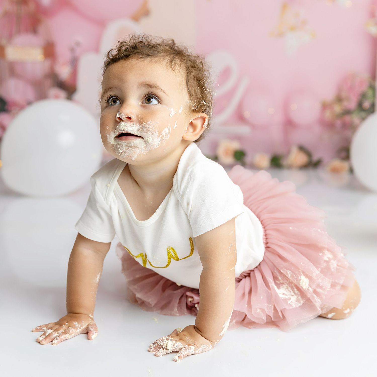 Photograph of little girl crawling on set of her cake smash photography session, cake smash & splash with Shelly Loxton Photography