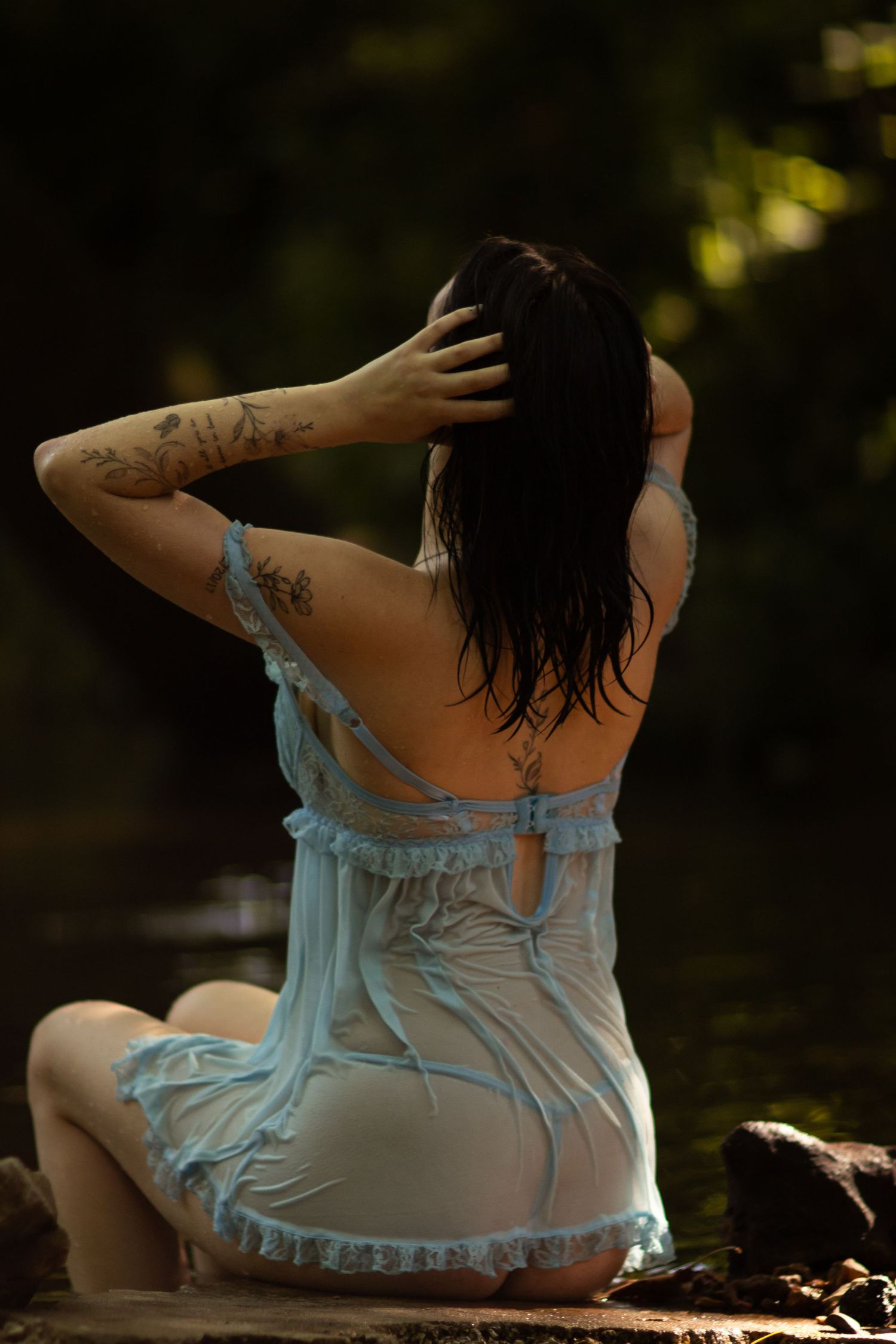 Girl in a blue dress with her back to the camera during a Joplin, Missouri boudoir photo session.