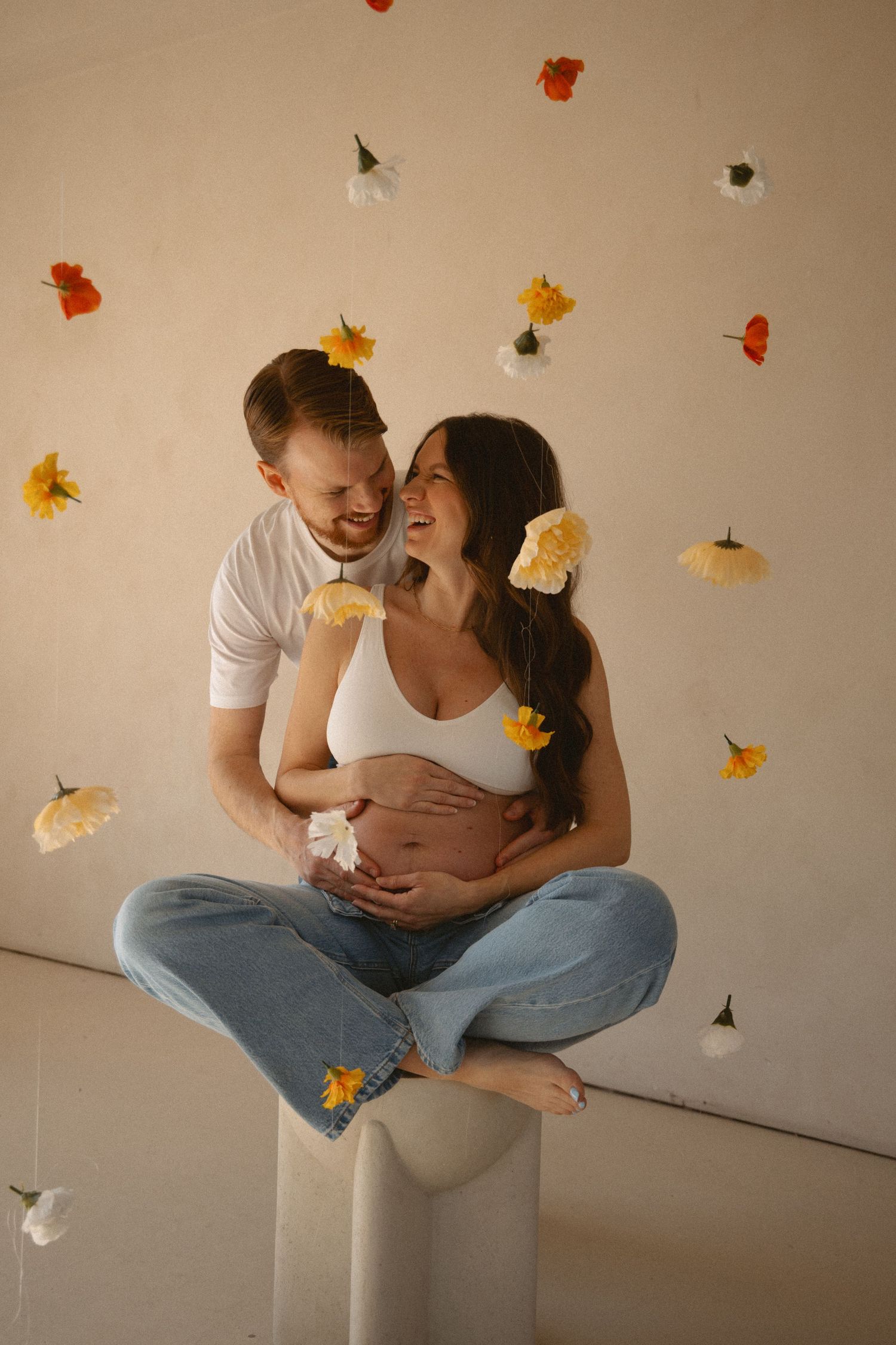 Colourful flower maternity photos indoors.