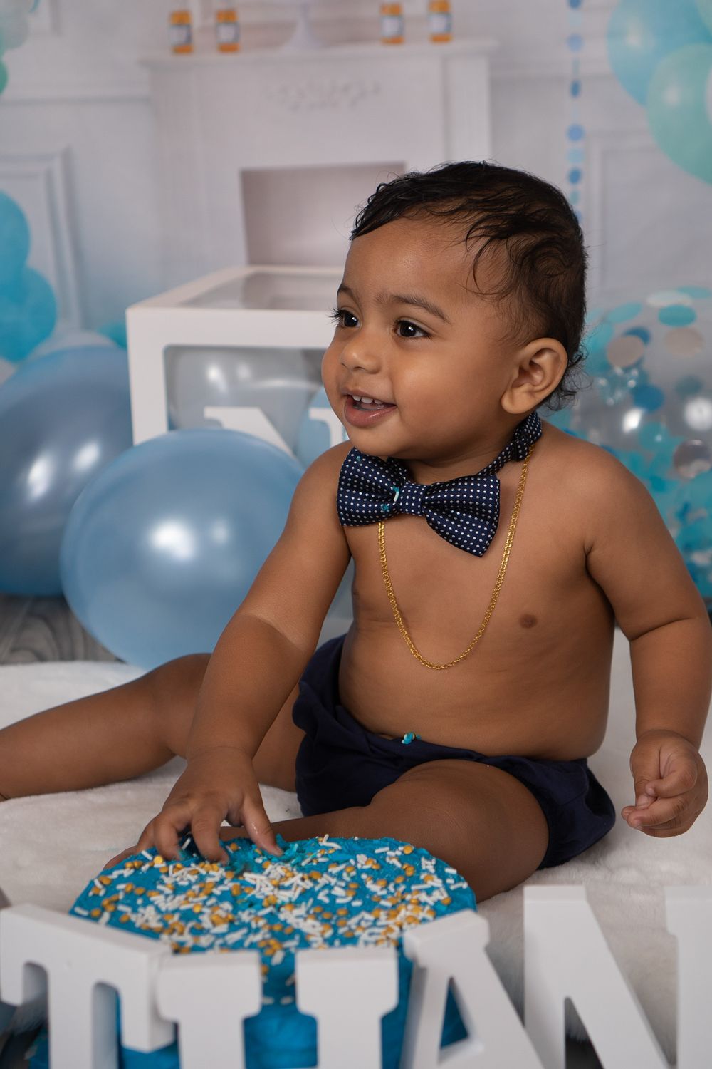 Birthday setup with blue balloons and sparkly cake decorations.