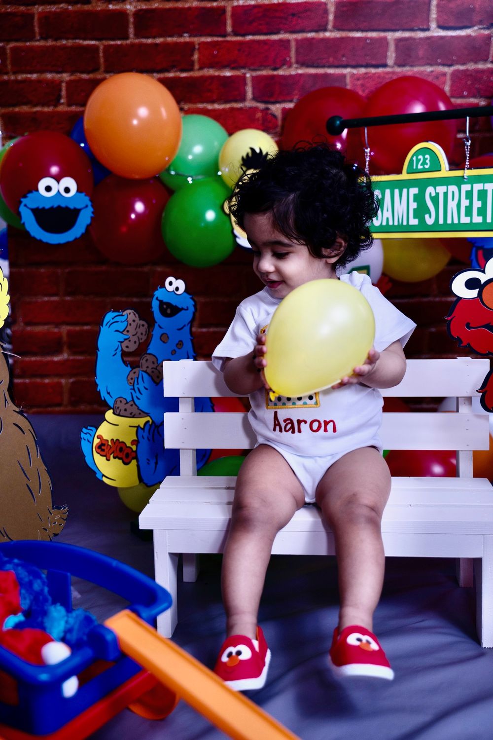 Sesame Street themed birthday setup with colorful balloons and character decorations.