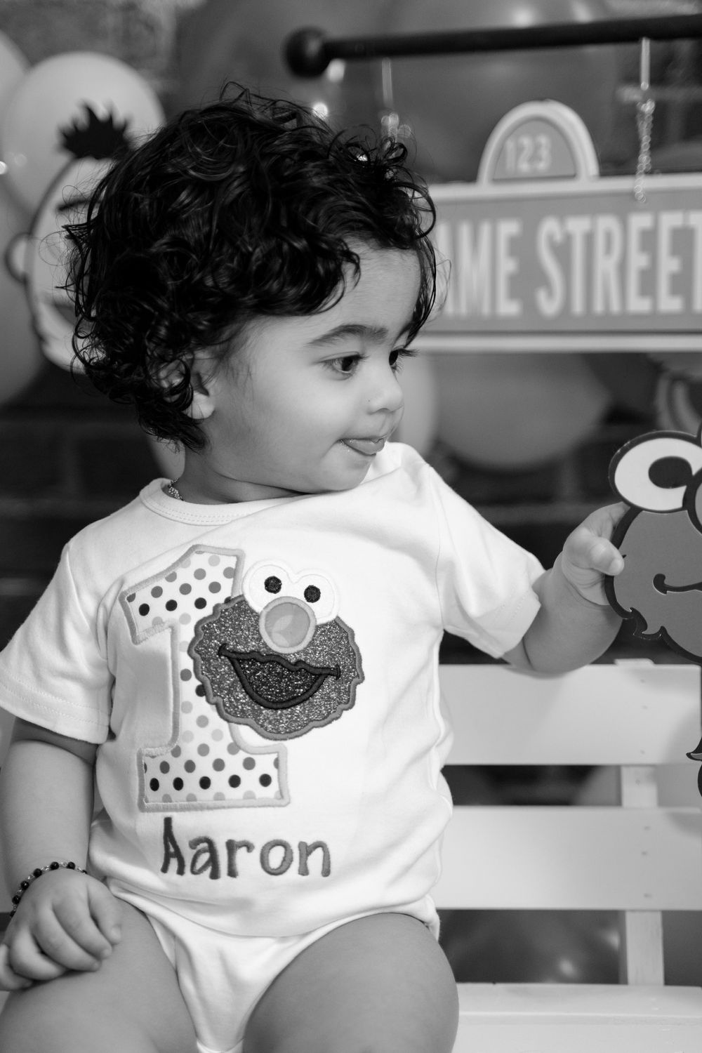 Baby wearing Sesame Street themed onesie with custom name in black and white portrait.