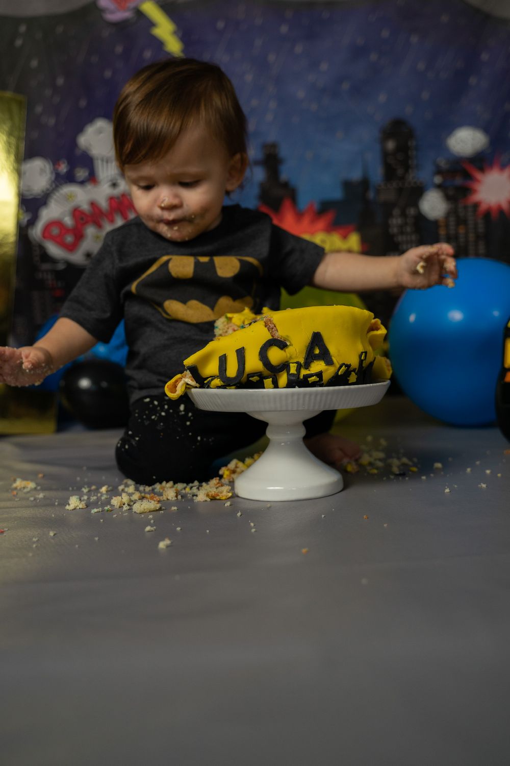 A Batman-themed smash cake setup with a cityscape backdrop for a special celebration.